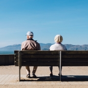 retirement planning and aged care financial advice for retired people, retired couple sitting on a bench